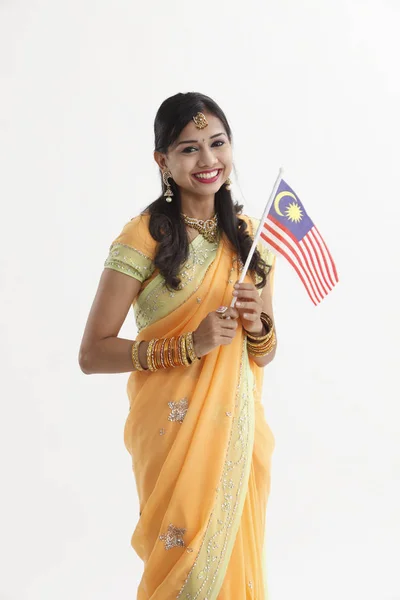 マレーシアのフラグお祝いムルデカを保持している魅力的な伝統的な服でインドの女性 — ストック写真
