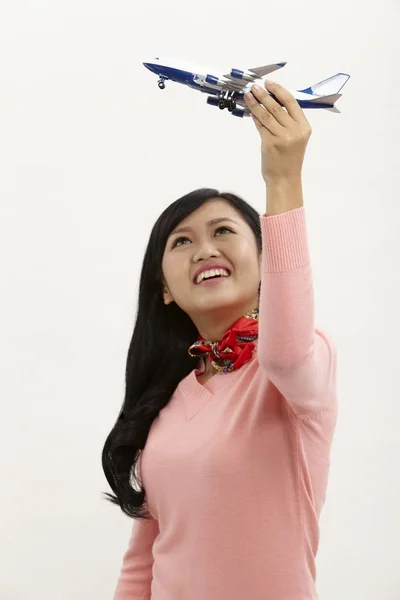 Asiatische Stewardess Hält Ein Spielzeugflugzeug — Stockfoto