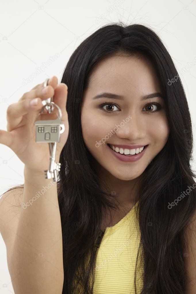 malay young woman holding house shaped key chain