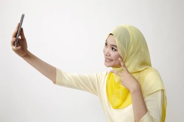 Malay kadın holding akıllı kullanarak telefon kendi kendine portre