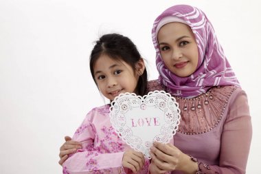 bir kalp şekli afiş bir arada tutan kızı ile Malay kadınla 
