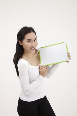 bir beyaz tahta tutan malay kadın