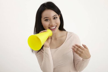 beyaz zemin üzerine sarı megafon kullanan malay kadın 