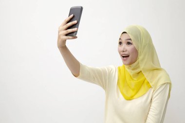 Malay kadın holding akıllı kullanarak telefon kendi kendine portre