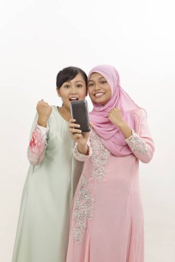 akıllı telefon olan iki mutlu genç Müslüman kadın