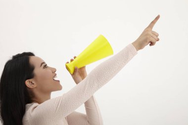 beyaz zemin üzerine sarı megafon kullanan malay kadın 