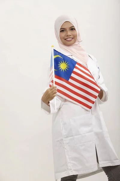 白い背景の上のマレーシアの国旗を保持しているマレーの女性医師 — ストック写真