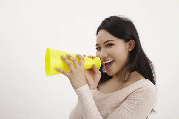 在白色背景上使用黄色扩音器的马来妇女 — 图库照片