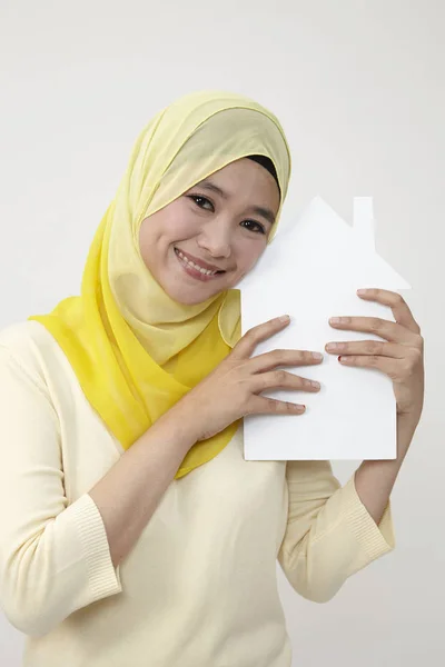 马来妇女持有一个白色的房子形状切出的纸张 — 图库照片