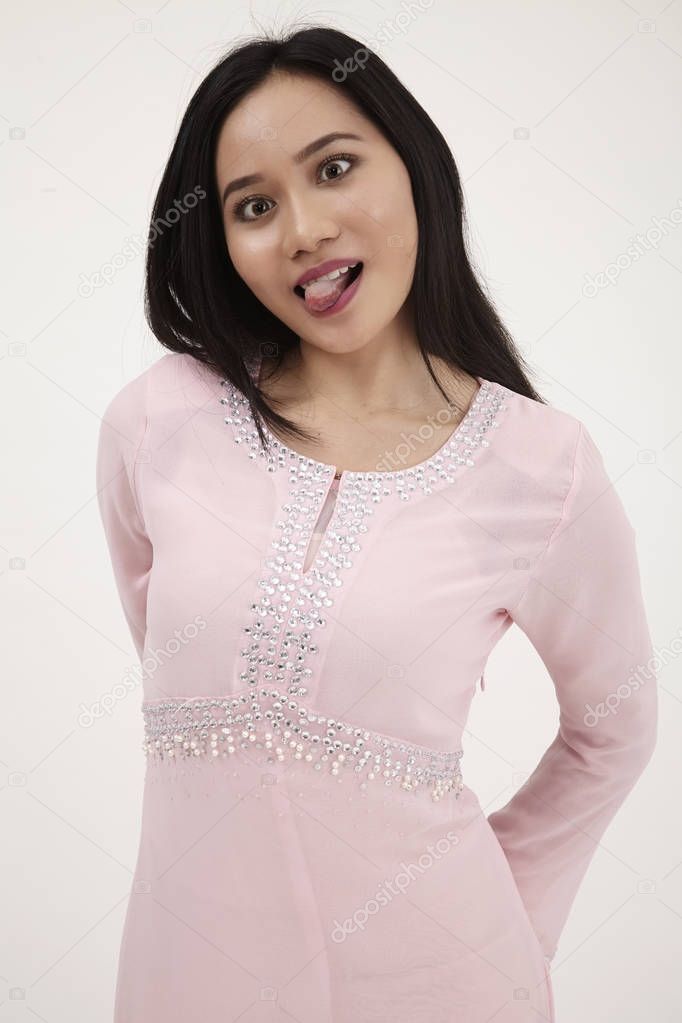 malay woman wearing pink baju kurung traditional clothes posing in studio