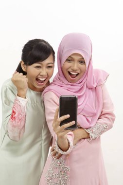 akıllı telefon olan iki mutlu genç Müslüman kadın