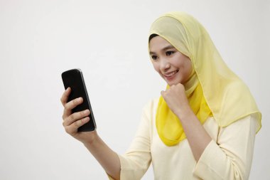 Malay kadın holding akıllı kullanarak telefon kendi kendine portre