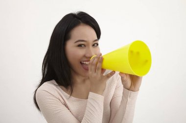 beyaz zemin üzerine sarı megafon kullanan malay kadın 