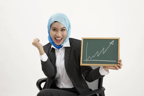 Malaiische Geschäftsfrau Sitzt Auf Bürostuhl Und Hält Tafel Mit Diagrammaufstellung — Stockfoto