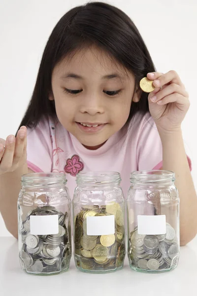 Poco Con Tres Frascos Ahorro Con Monedas —  Fotos de Stock