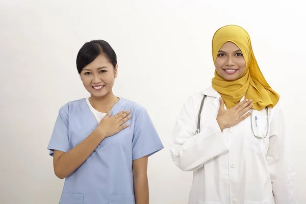 亚洲护士和医生在白色背景上的欢迎手势 — 图库照片
