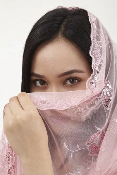 malay woman wearing pink baju kurung traditional clothes posing in studio