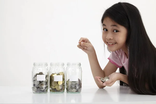 little with three saving jars with coins