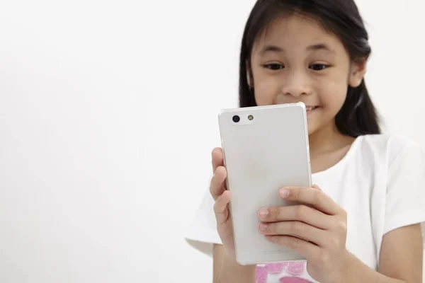 童年和技术 可爱的小女孩使用智能手机 隔离在白色 — 图库照片