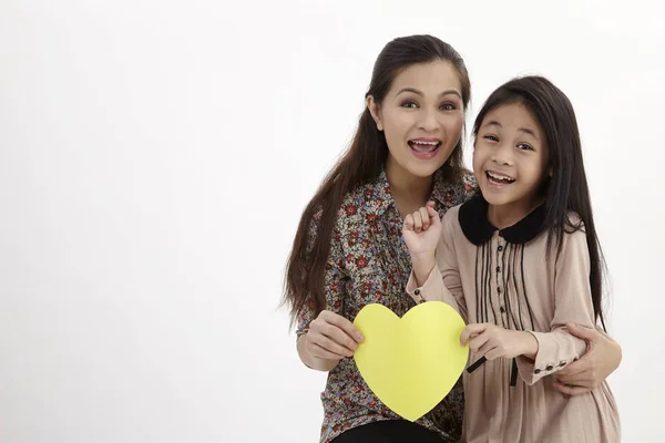 Mutter Und Tochter Halten Eine Gelbe Leere Herzförmige Papptafel Der — Stockfoto