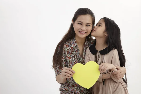 Madre Hija Sosteniendo Una Tarjeta Amarilla Blanco Con Forma Corazón —  Fotos de Stock
