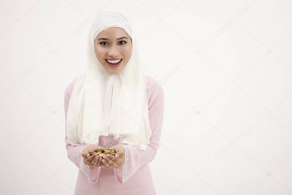 young muslimah hand full of coins, saving concept