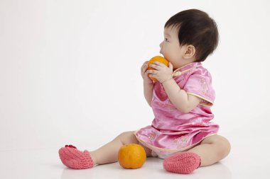 Çinli bebek bir mandarin portakal holding cheomgsam giyiyor