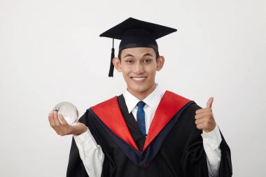 malay genç mezun öğrenci bir küre tutan 