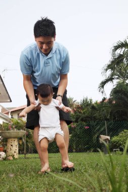 Baba ve oğul parkta oynarken