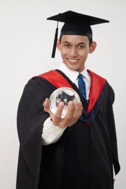 malay genç mezun öğrenci bir küre tutan 