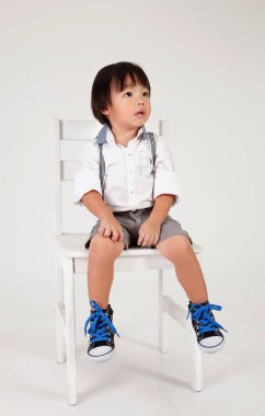 Çinli çocuk büyük taburede oturan