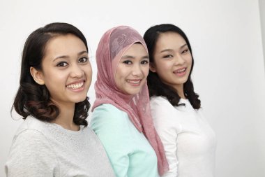 Üç multi ırksal malaysians kameraya bakarak üst üste duran