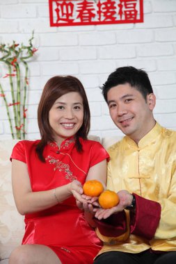 Çinli çift Çin yeni yılı dekorasyon tebrik ile kanepede oturan