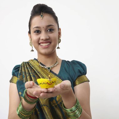 Sarı kandil tutan saree giyen kadın