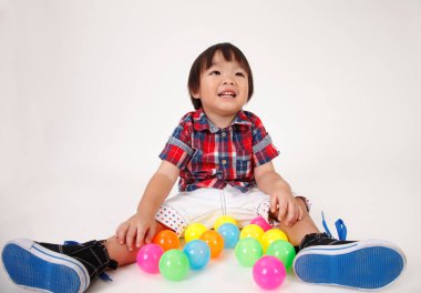 Çinli çocuk oyuncakları ile oynarken oturuyor