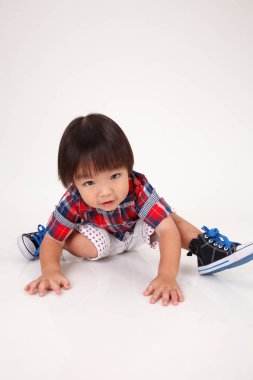 Çinli çocuk beyaz arka plan üzerinde oturan stüdyo çekim