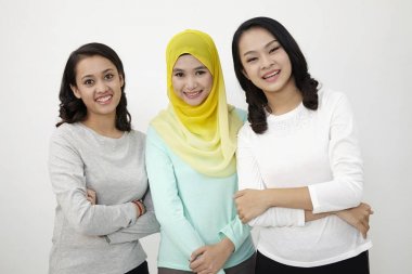 Üç multi ırksal Malezya ayakta yan kameraya bakıyor