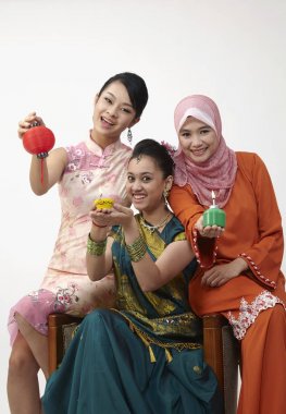 three Malaysian young beautiful girls posing in studio  clipart