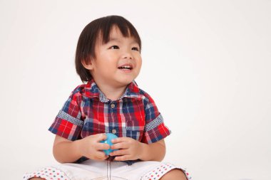 Çinli çocuk oyuncakları ile oynarken oturuyor