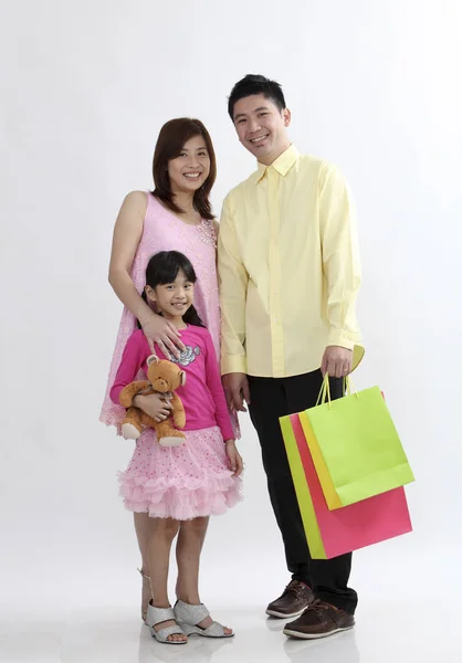 chinese parent holding shopping bag with young daughter