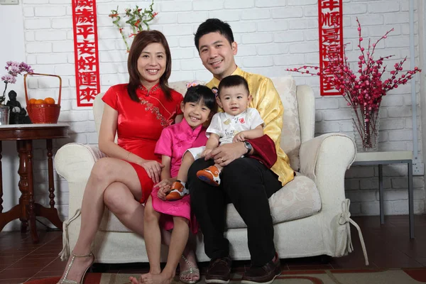 Çin yeni yılı dekorasyonu ile kanepede oturan Çinli aile 