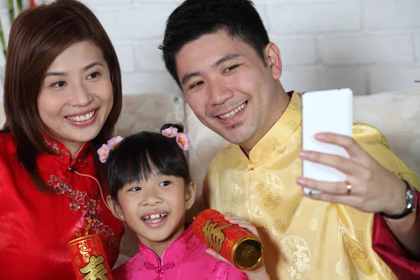Çin yeni yılı dekorasyonu ile kanepede oturan Çinli aile 