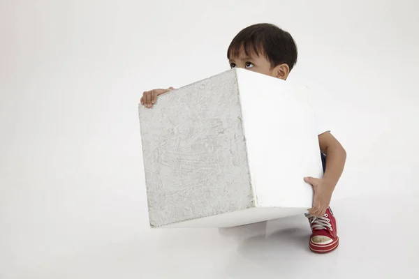 Chico Tratar Levantar Una Caja Blanca Pesada —  Fotos de Stock