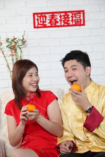 Çinli çift Çin yeni yılı dekorasyon tebrik ile kanepede oturan