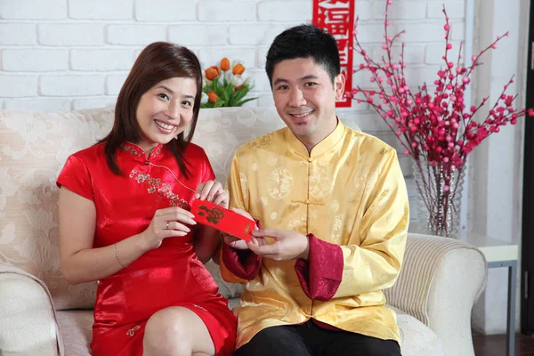 Çinli çift Çin yeni yılı dekorasyon tebrik ile kanepede oturan
