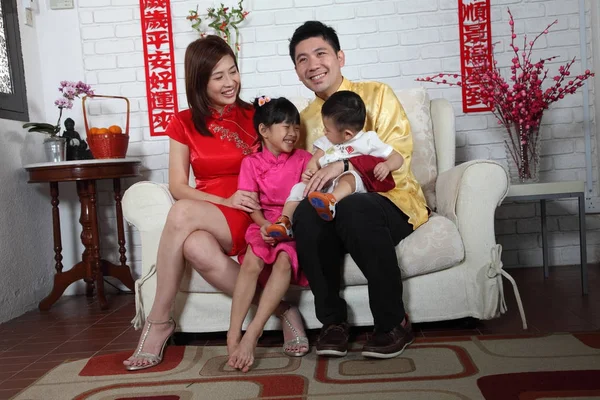 Çin yeni yılı dekorasyonu ile kanepede oturan Çinli aile 