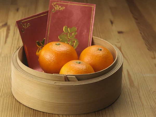 persimmons in a basket o with chinese red envelope