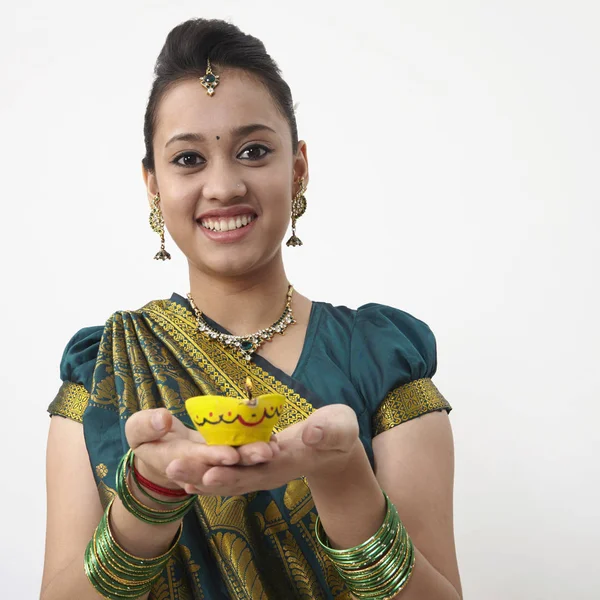 Sarı kandil tutan saree giyen kadın