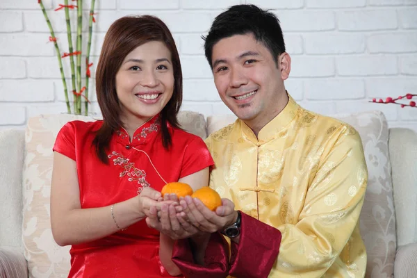 Çinli çift Çin yeni yılı dekorasyon tebrik ile kanepede oturan