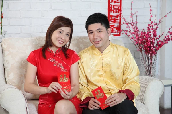 chinese couple sitting on the sofa with chinese new year decoration greeting